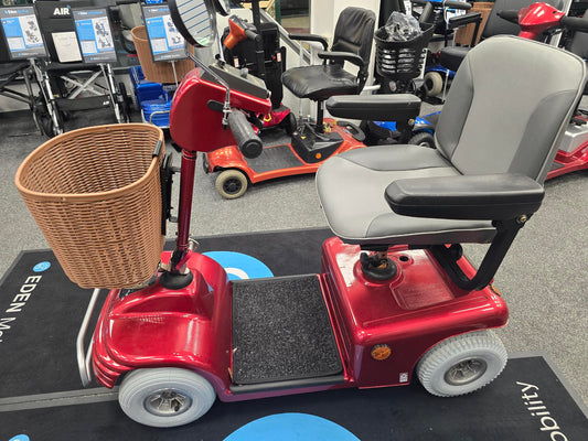 Red Roma Sovereign 4 mobility scooter with cushioned seat and front woven basket, displayed indoors for sale.