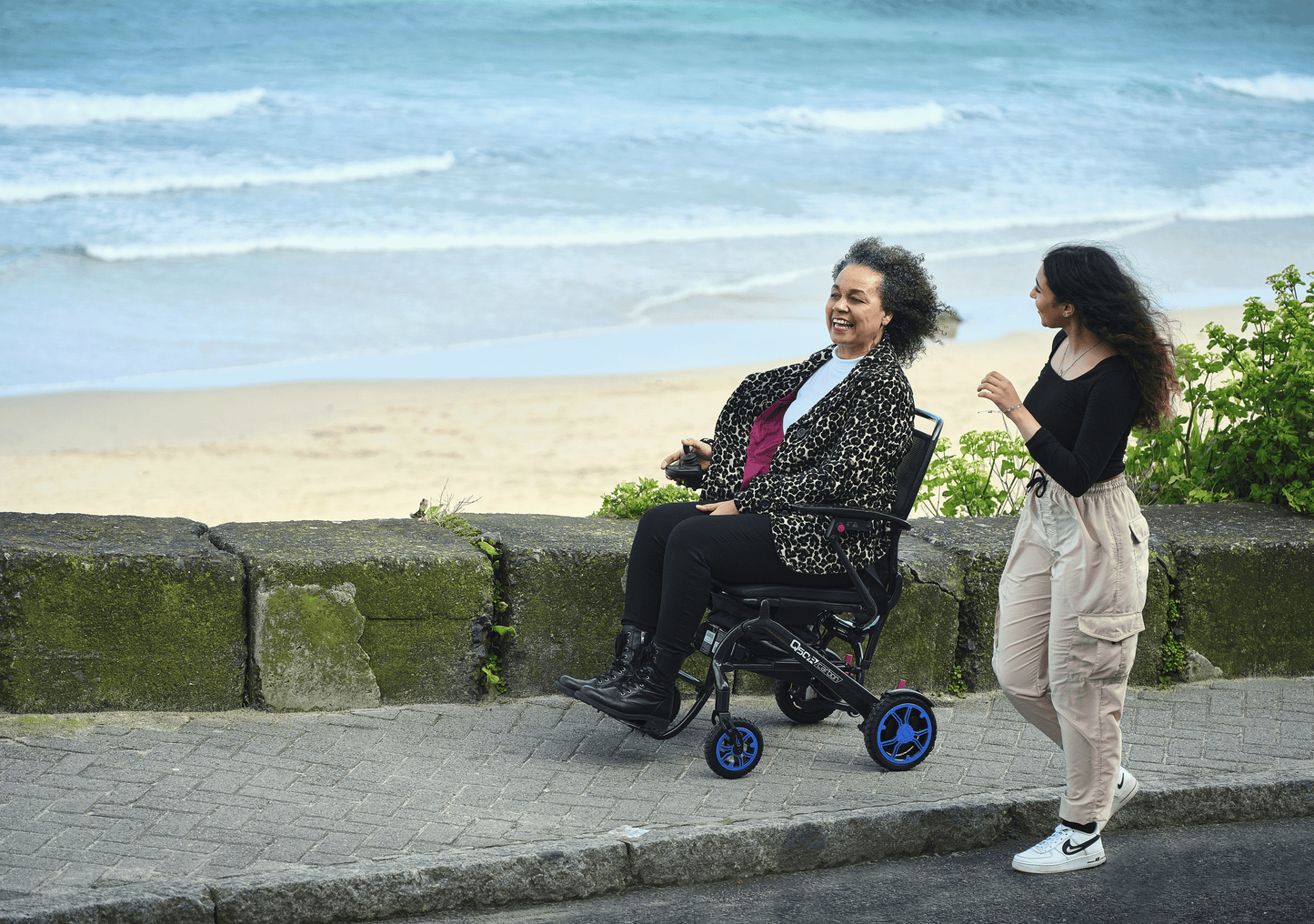 Woman in wheelchair by the beach