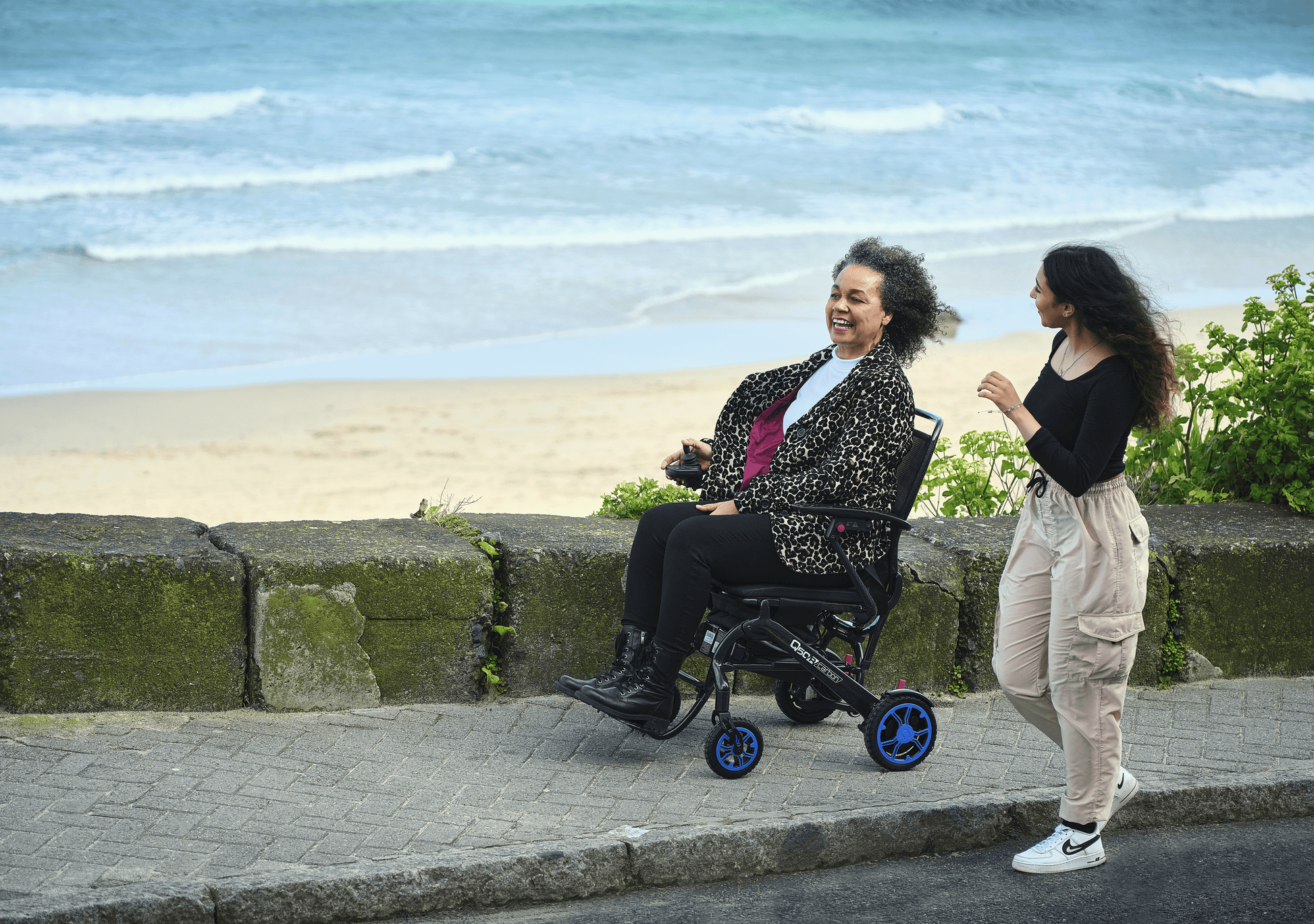 Woman in wheelchair by the beach
