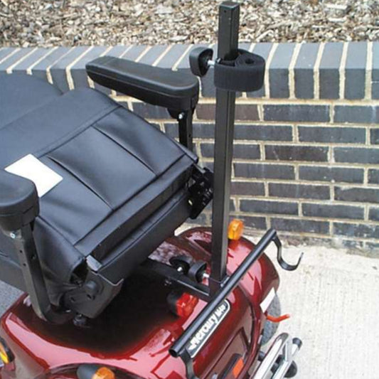 Black walker holder rack on a red mobility scooter with a brick wall background