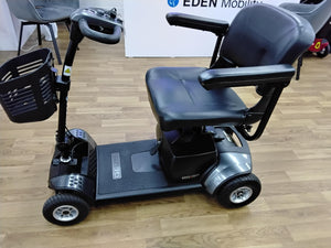 Refurbished Pride Go Go Elite Traveller mobility scooter in grey with padded seat and basket on wood floor in Wrexham showroom