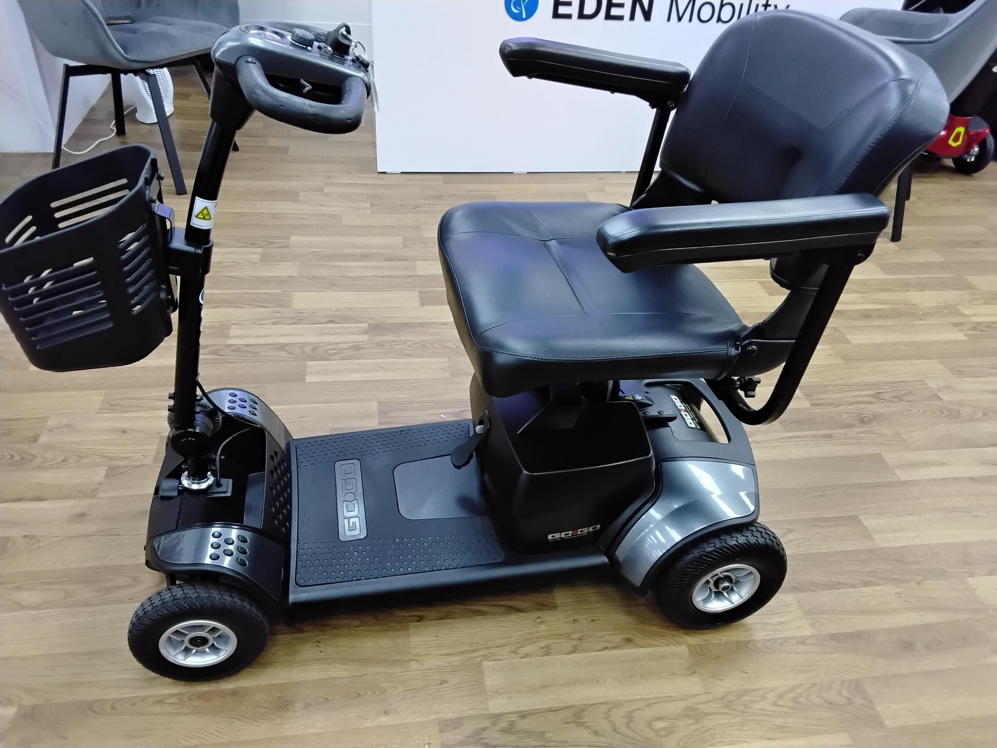 Refurbished Pride Go Go Elite Traveller mobility scooter in grey with padded seat and basket on wood floor in Wrexham showroom