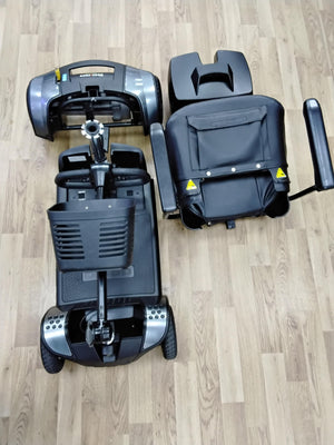 Disassembled Pride Go Go Elite Traveller mobility scooter in grey, shown on wooden floor after refurbishment and inspection.