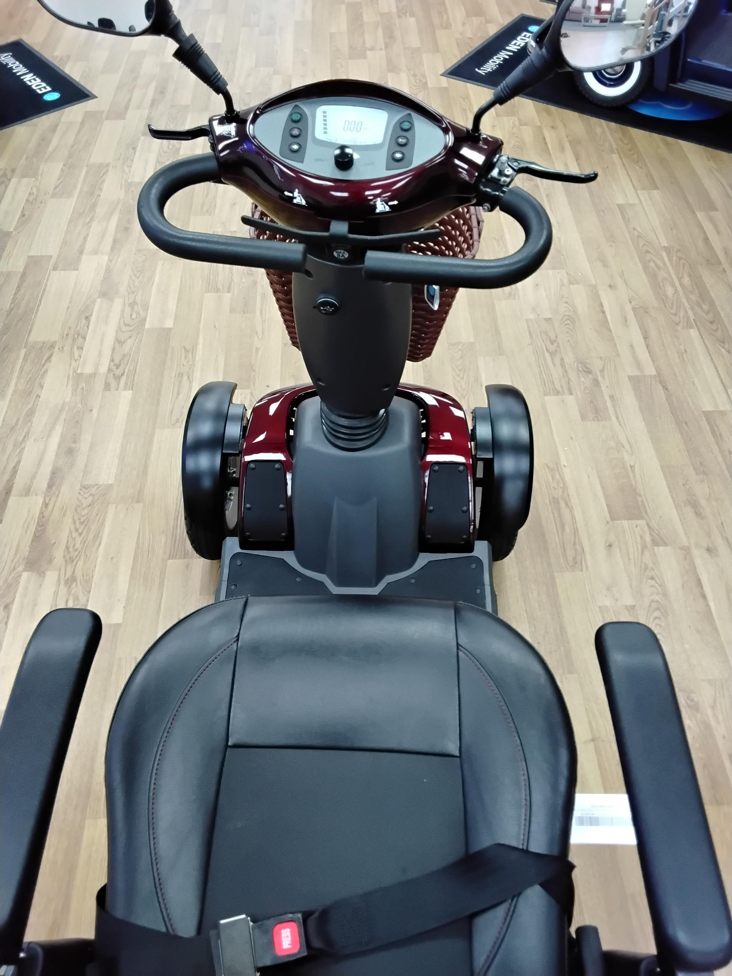 Top-down view of a fully refurbished maroon Roadmaster Plus R mobility scooter on wooden floor