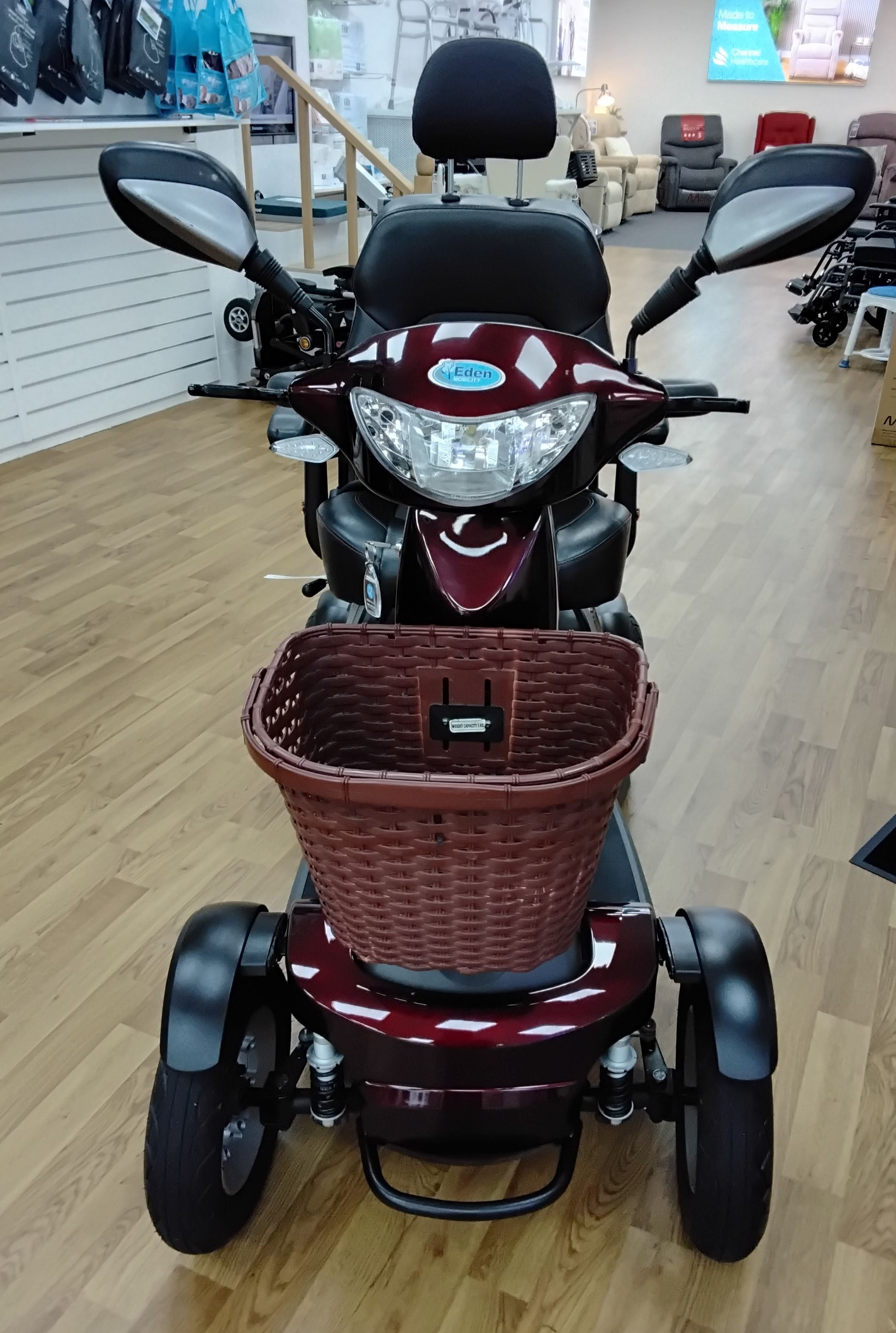 Front view of refurbished maroon Roadmaster Plus R mobility scooter with basket in showroom background
