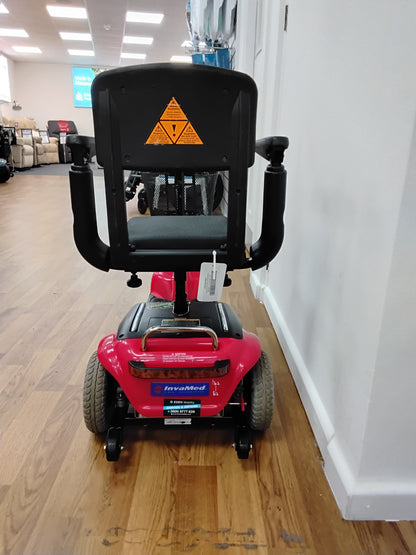 Rear view of a fully refurbished red Shoprider Whisper mobility scooter with black seat and armrests on wood flooring