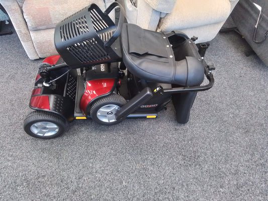 Red Pride Go Go Elite Traveller mobility scooter with black seat and basket on gray carpet indoors