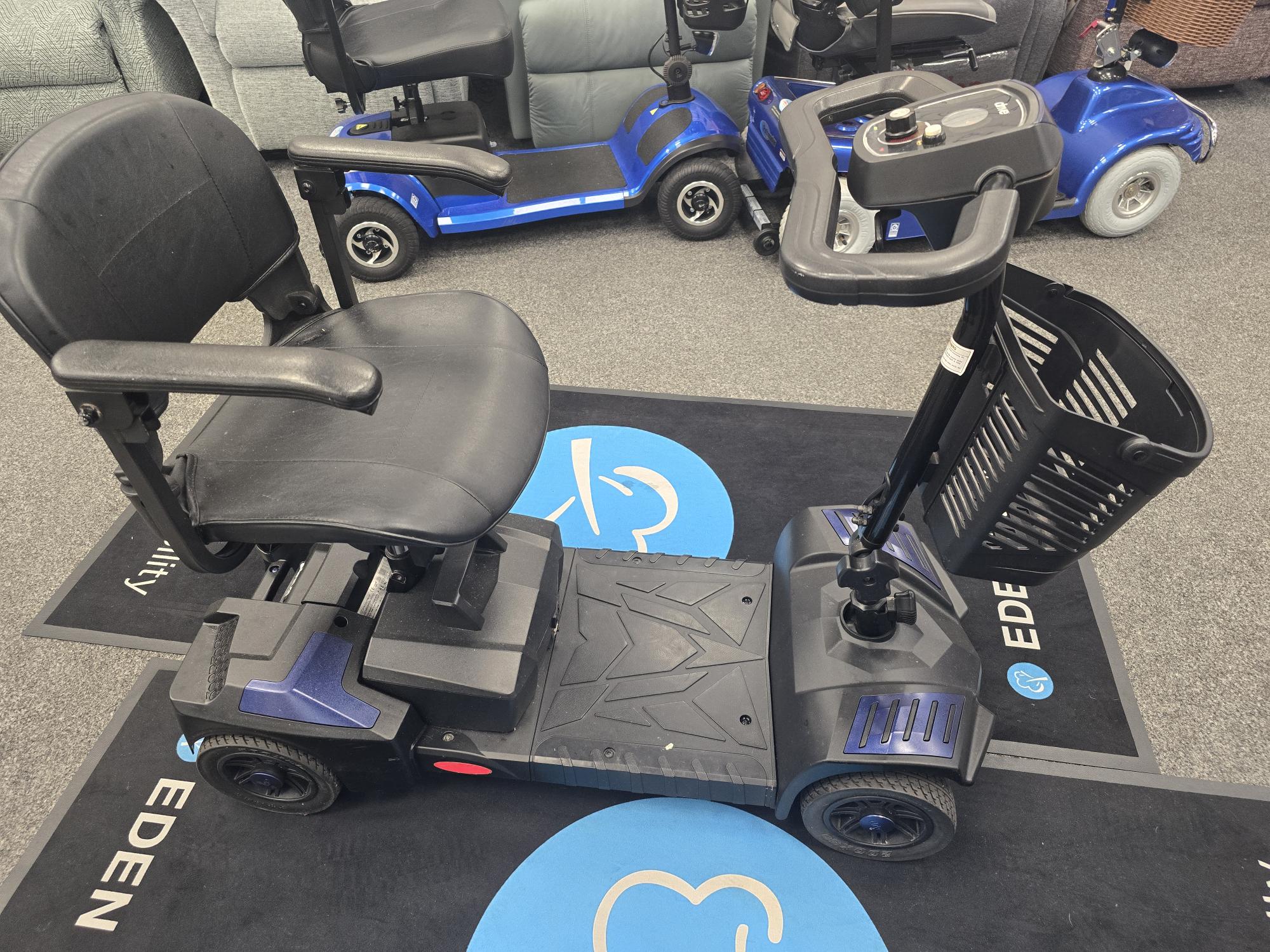 Fully refurbished Drive Scout mobility scooter in blue with black seat and front basket on showroom floor.
