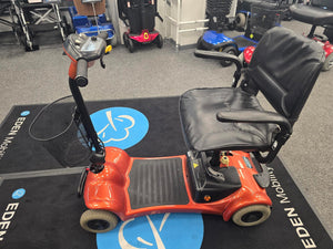 Electric Mobility Ultralite 480 orange refurbished mobility scooter with padded seat and basket on showroom floor