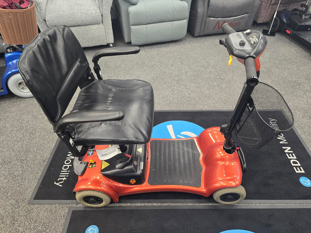 Refurbished Electric Mobility Ultralite 480 orange mobility scooter with black seat and basket on display indoors