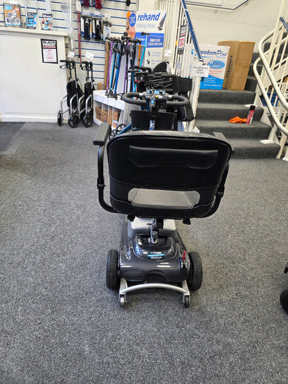 Rear view of a refurbished grey Liberty komfi Rider mobility scooter inside a showroom with walking aids in the background