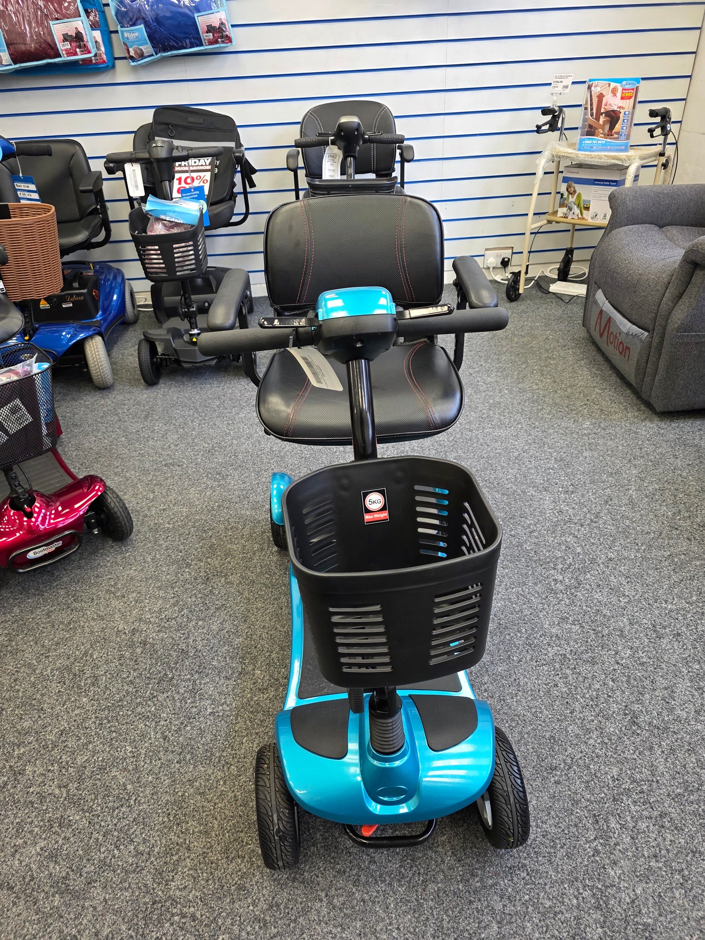 Blue Li-tech Air mobility scooter with front basket on display in a showroom with other scooters nearby