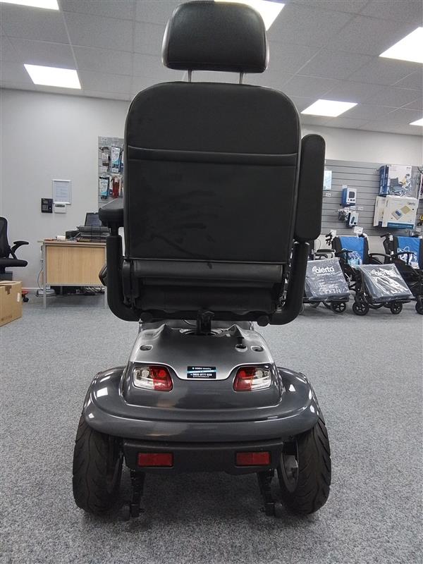 Rear view of a grey Kymco Maxi XLS mobility scooter with padded seat and armrests in showroom setting