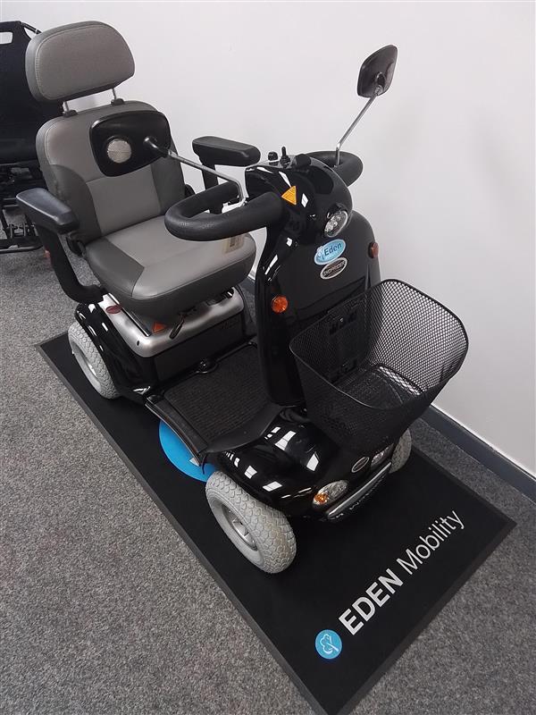 Black Roma Shoprider Cadiz mobility scooter with grey seat and front basket displayed indoors on Eden Mobility mat