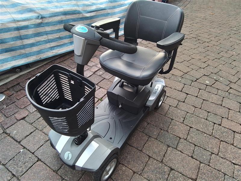 Refurbished Rascal Veo Sport grey mobility scooter with padded seat, armrests, and front basket on paved surface