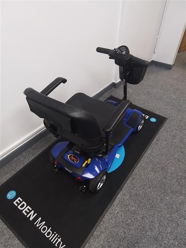 Refurbished Pride Apex Lite Blue mobility scooter with black seat and armrests on Eden Mobility mat indoors