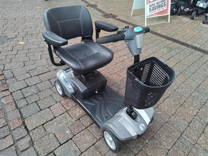 Refurbished Rascal Veo Sport grey mobility scooter with comfortable seat and front basket parked on cobblestone path