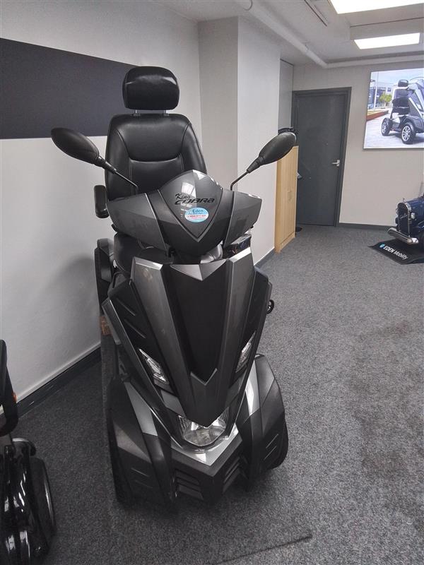 Grey Drive King Cobra mobility scooter with padded seat and mirrors in a showroom setting