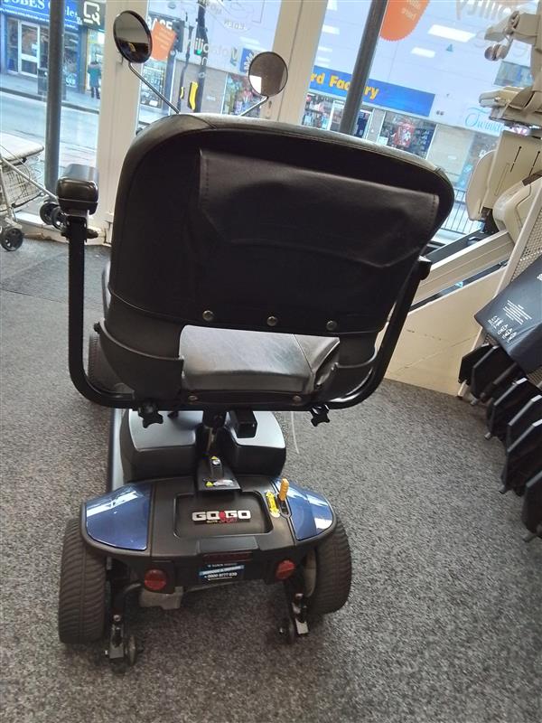 Rear view of refurbished Pride Go Go Elite Traveller mobility scooter with new batteries on display indoors