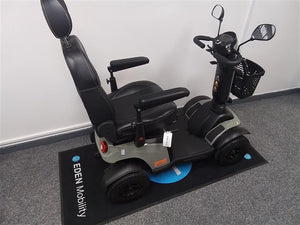 Refurbished Excel Evo green mobility scooter with black seat, armrests, front basket, and four wheels on Eden Mobility mat