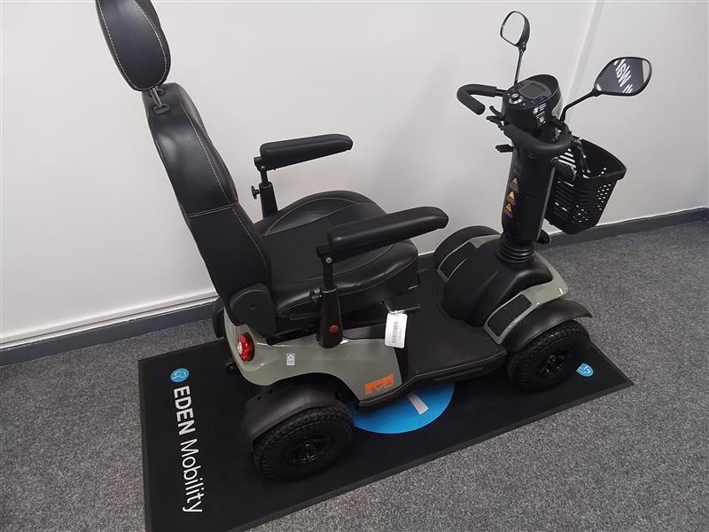 Refurbished Excel Evo green mobility scooter with black seat, armrests, front basket, and four wheels on Eden Mobility mat