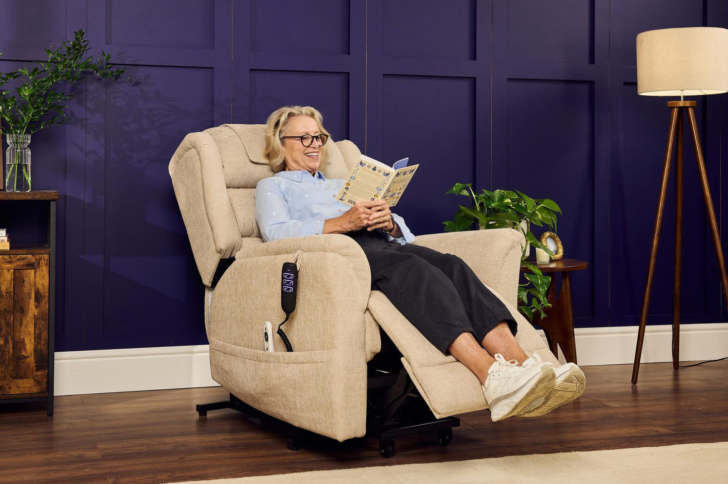 Woman relaxing in cream Sanford Rise and Recliner with footrest extended in a stylish living room setting