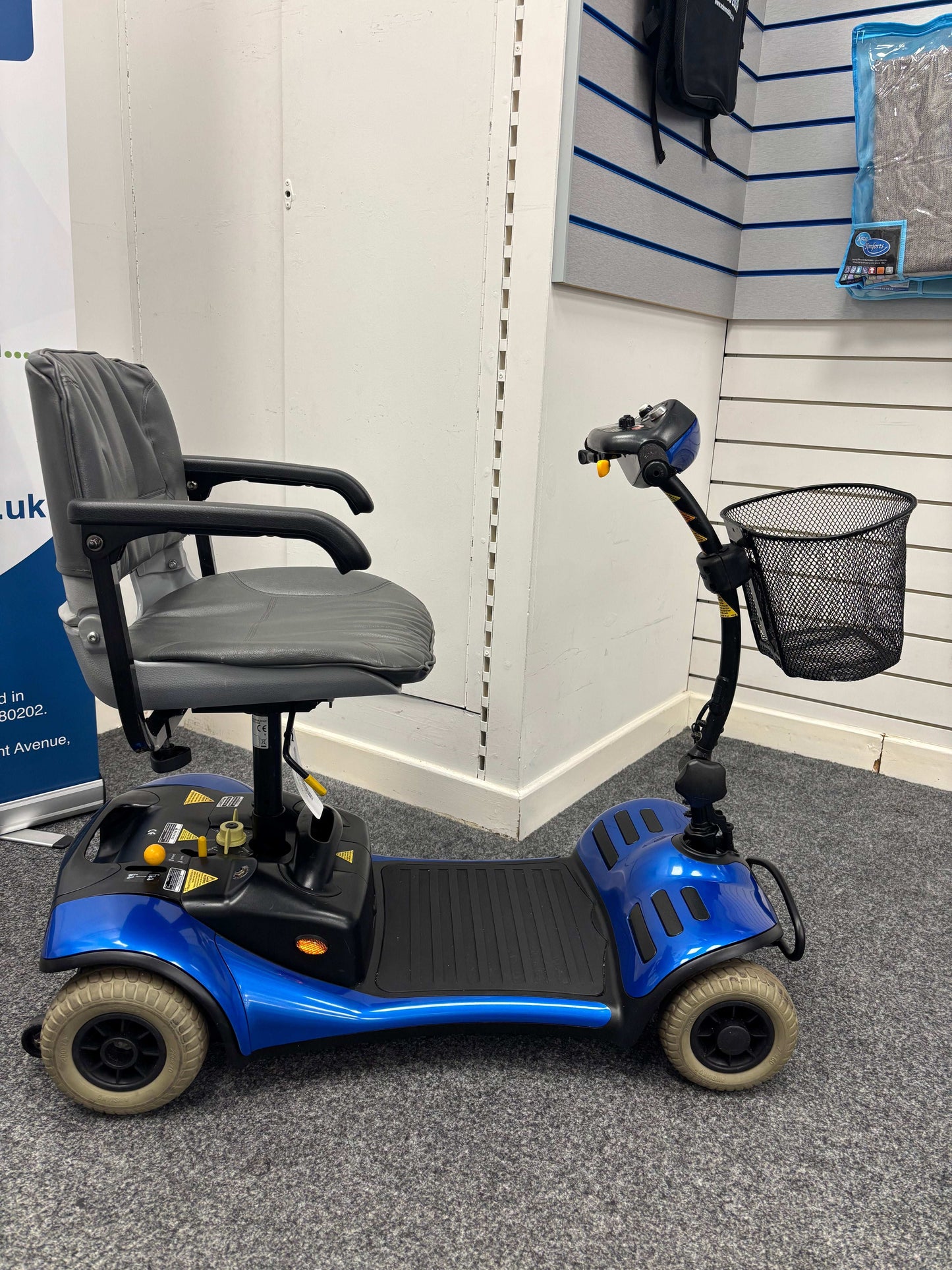 Side view of  Roma Cameo blue mobility scooter in shop