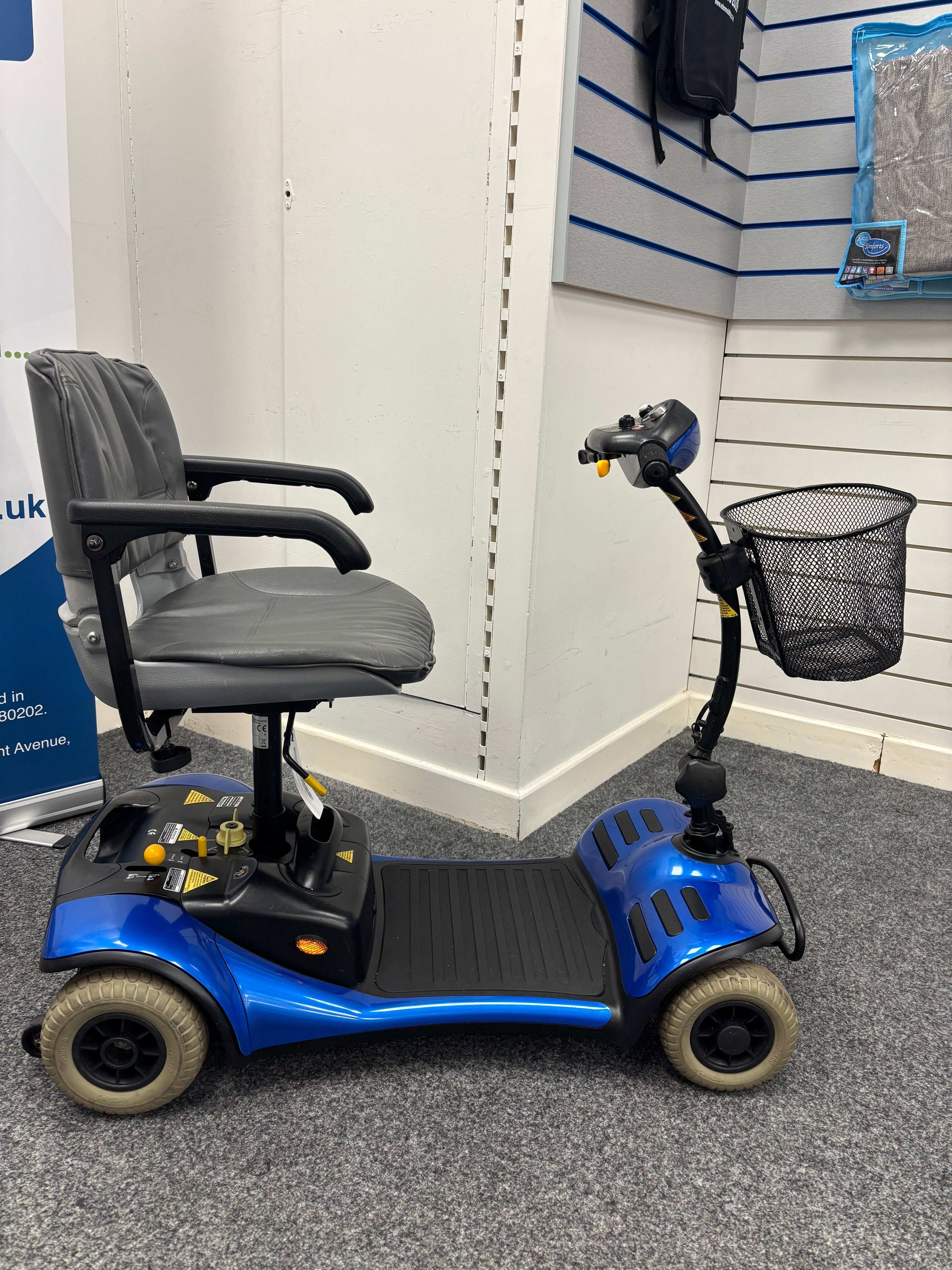 Side view of  Roma Cameo blue mobility scooter in shop