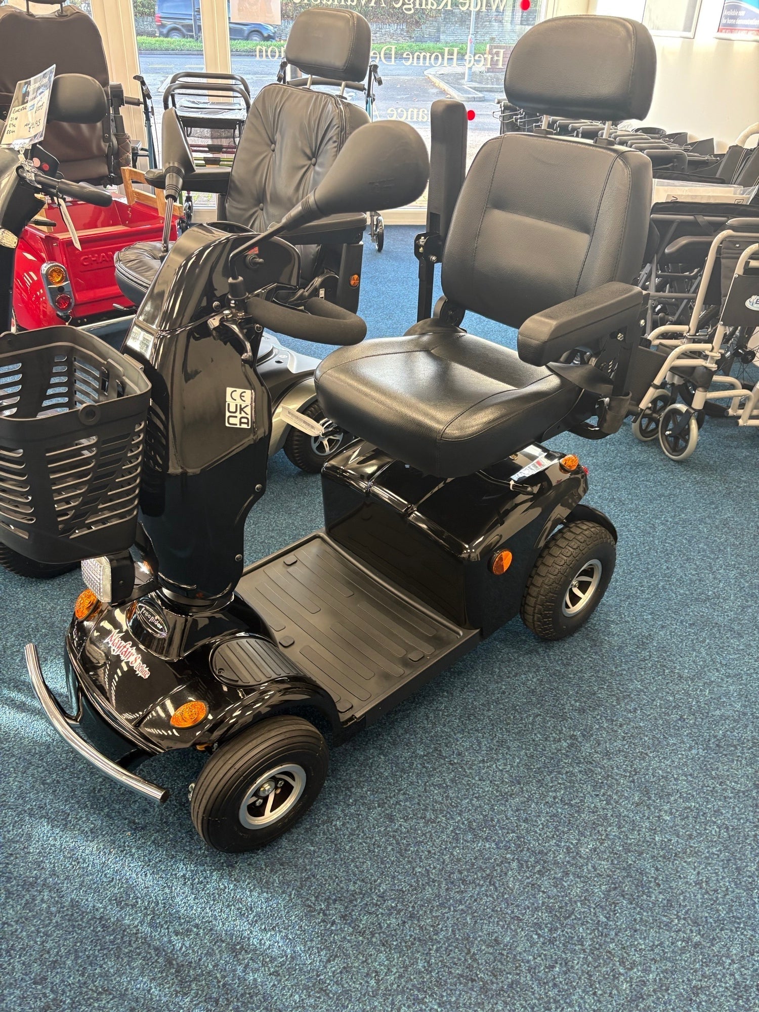 Refurbished black Freerider Mayfair mobility scooter with padded seat and basket on showroom floor