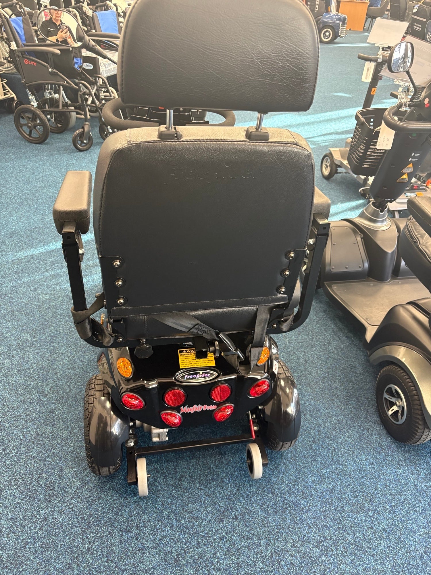 Rear view of a refurbished Freerider Mayfair Black Sheffield mobility scooter with new batteries on showroom floor