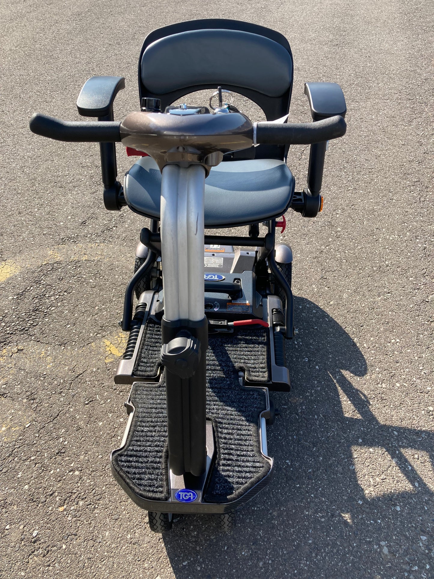 Top-down view of TGA Minimo - Bronze mobility scooter on a concrete surface