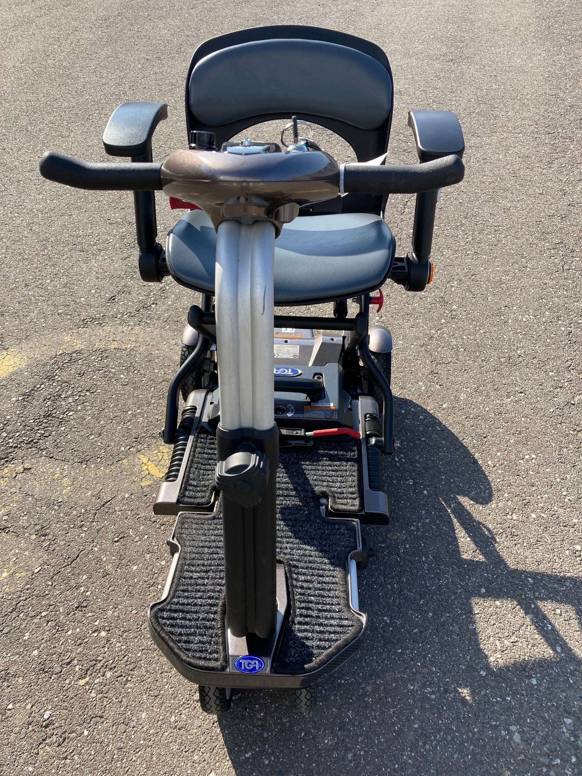 Top-down view of TGA Minimo - Bronze mobility scooter on a concrete surface