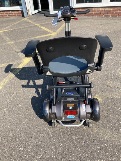 Back view of TGA Minimo - Bronze mobility scooter on a paved surface.