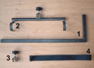 Set of metal brackets for a mobility scooter walker holder and components on a wooden surface