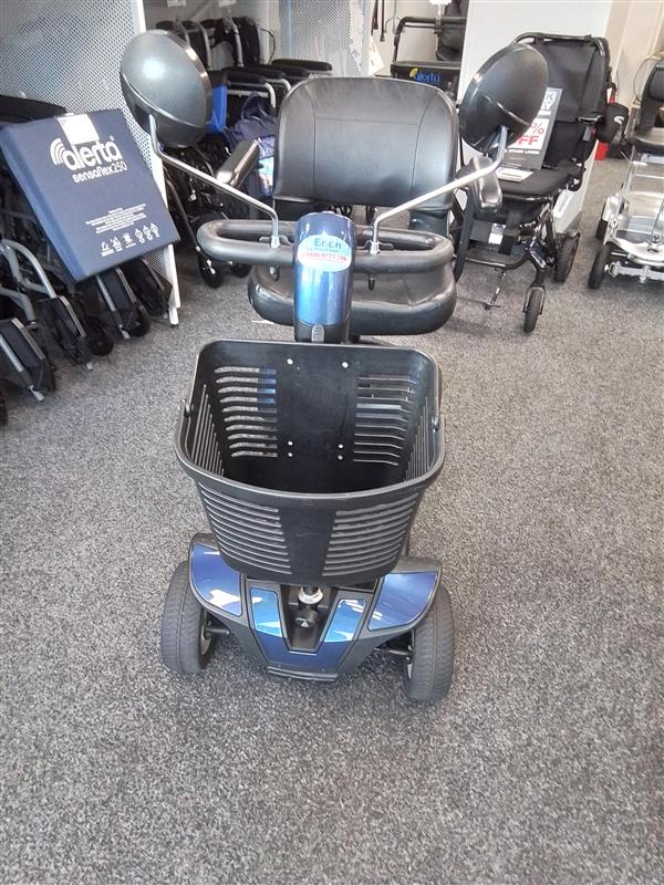 Front view of a refurbished blue Pride Go-Go Elite Traveller mobility scooter with basket and mirrors indoors
