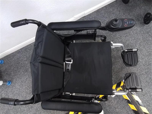 Top view of black Drive Cirrus powerchair with joystick control and padded seat on gray carpeted floor