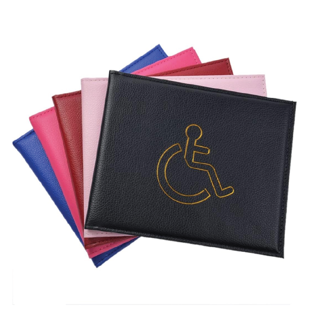 Stack of leather Blue Badge Parking Wallets in various colors, front wallet embossed with disability symbol on white background