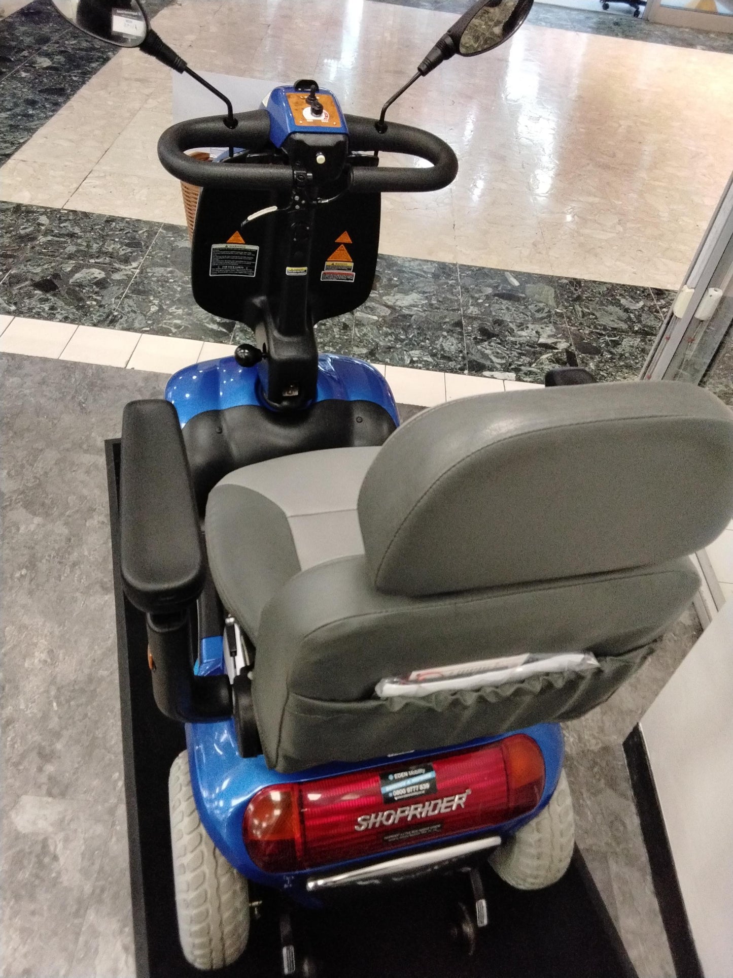Rear view of refurbished Roma Shoprider Cadiz mobility scooter in blue with cushioned seat and mirrors