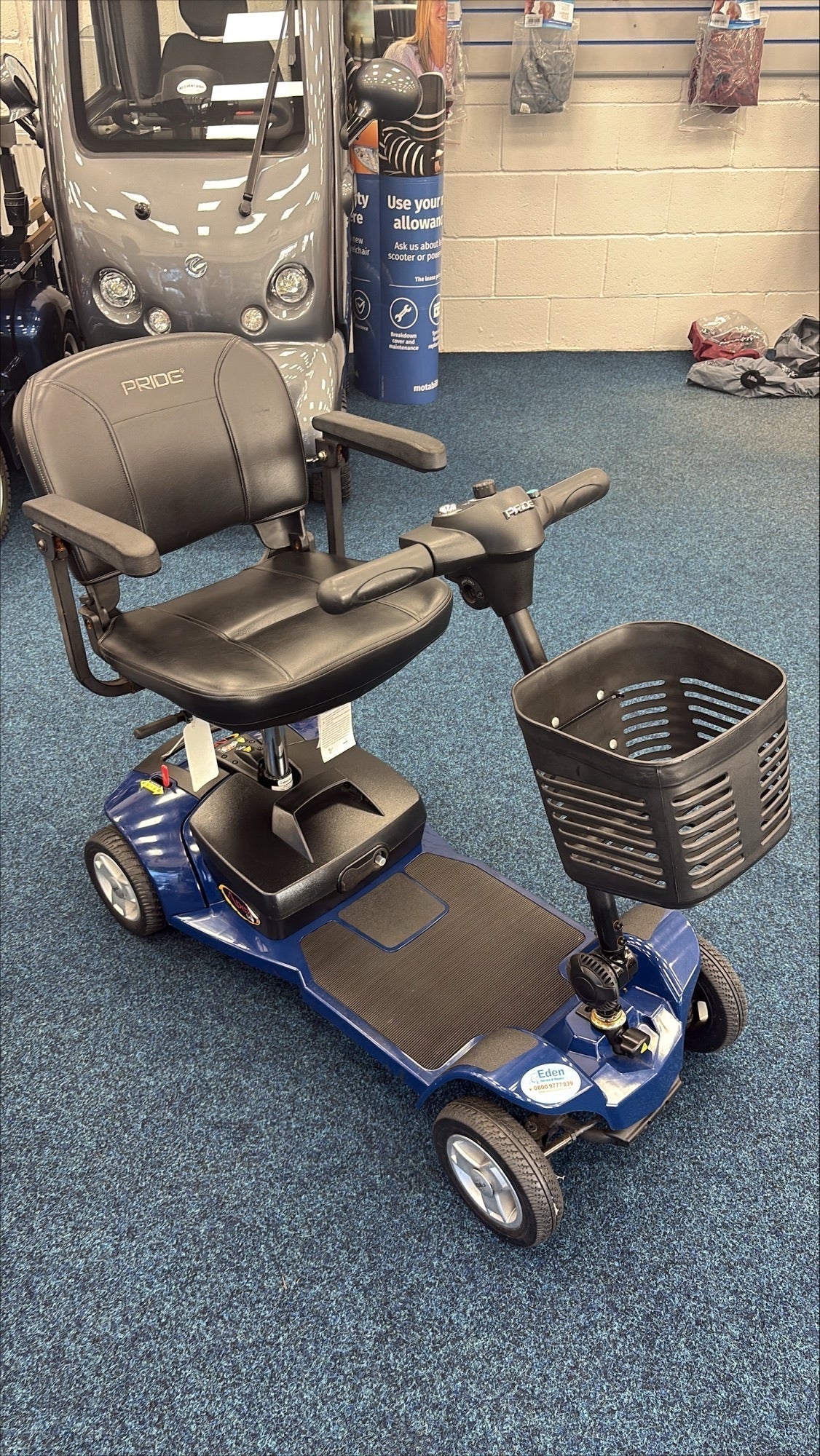 Refurbished Pride Apex Lite mobility scooter in blue with black seat and front storage basket on showroom floor