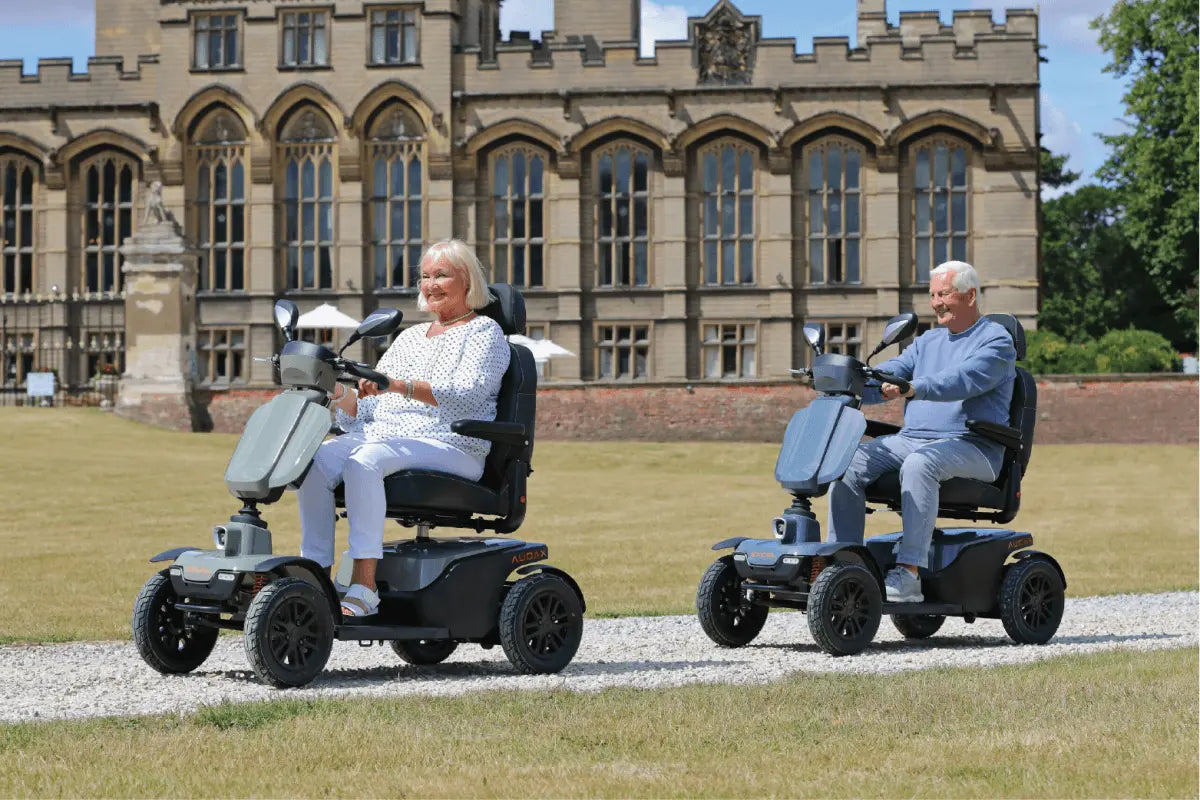 two people riding mobility scooters outside